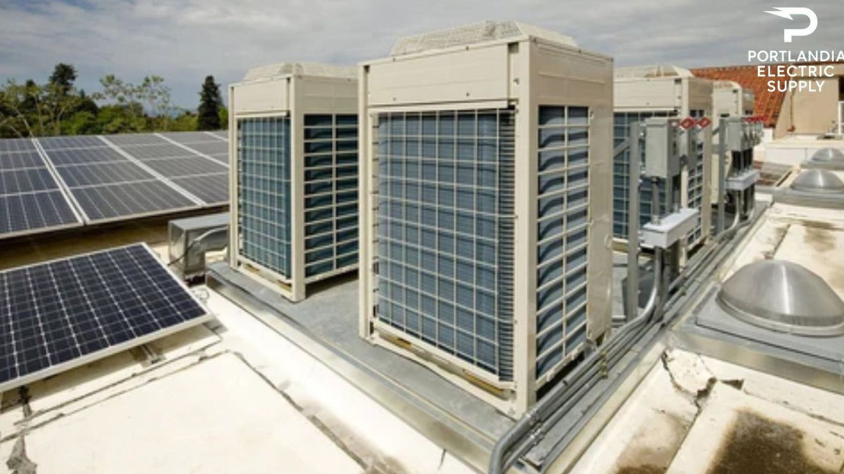 Rooftop solar panels and large AC units under cloudy sky, Portlandia Electric Supply logo visible.
