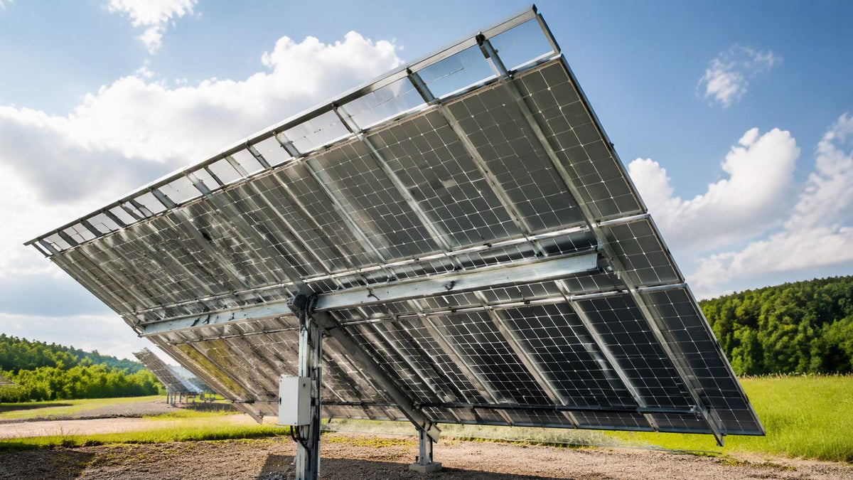 A large 144-cell bifacial solar panel on a ground-mount rack at a test site