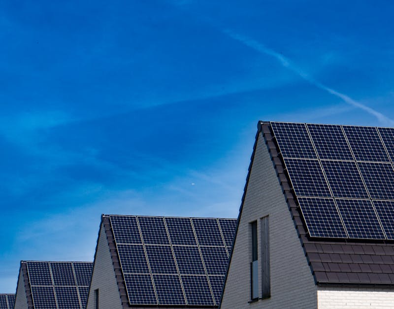 Modern houses with solar panels on rooftops under clear blue sky