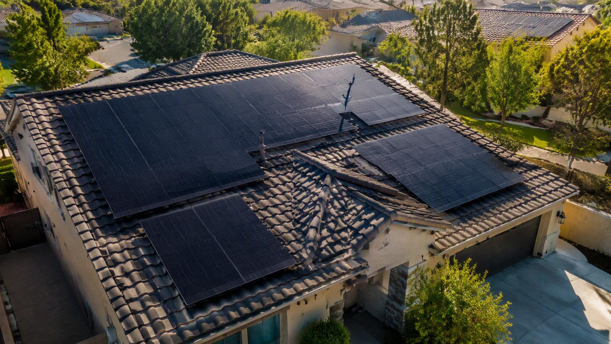 A residential rooftop with a full array of modern black solar panels