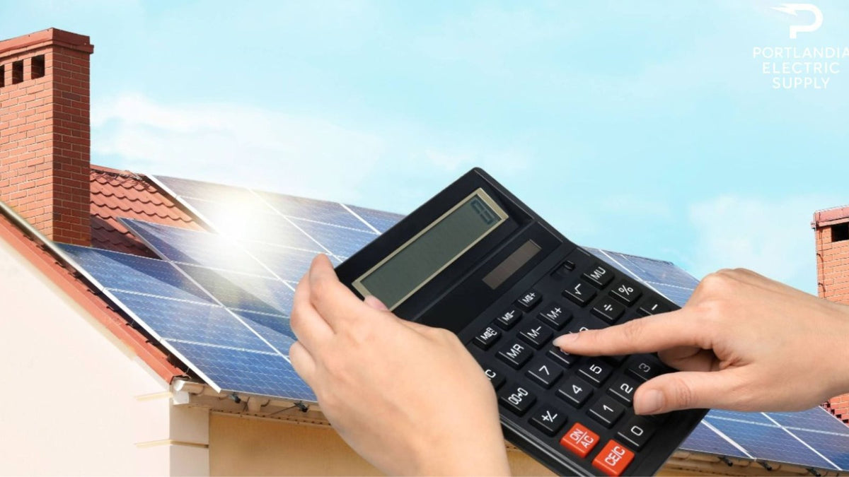 Hands using calculator in front of solar panels on house roof under blue sky