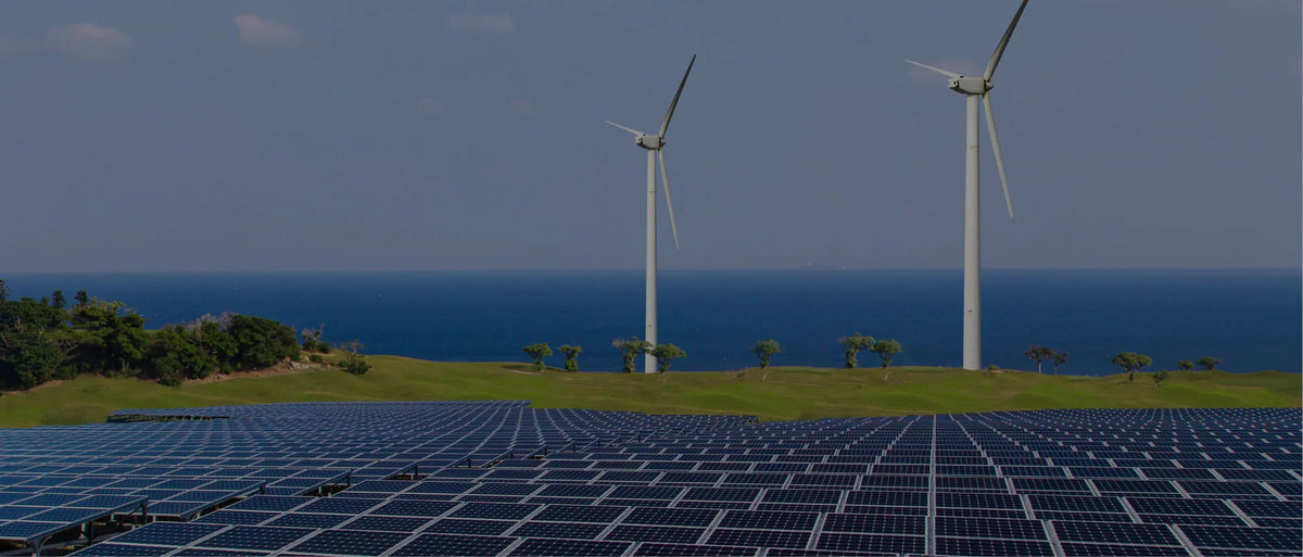 Solar panels and wind turbines on a green field by the ocean, renewable energy landscape