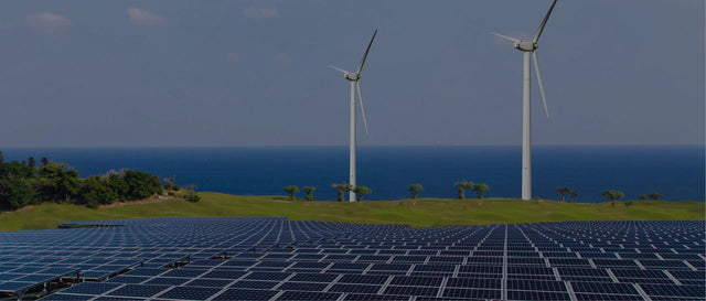 Solar panels and wind turbines on a green field by the ocean, renewable energy landscape