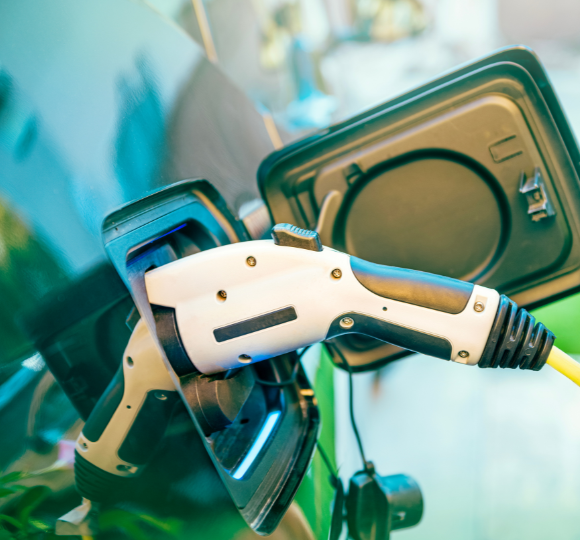 Electric vehicle charging cable being plugged into a car's charging port.