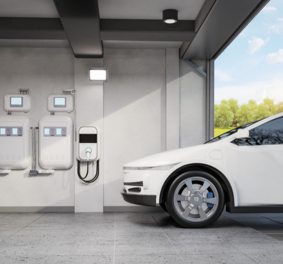 Electric car charging at a charging station with a clear sky and greenery outside.
