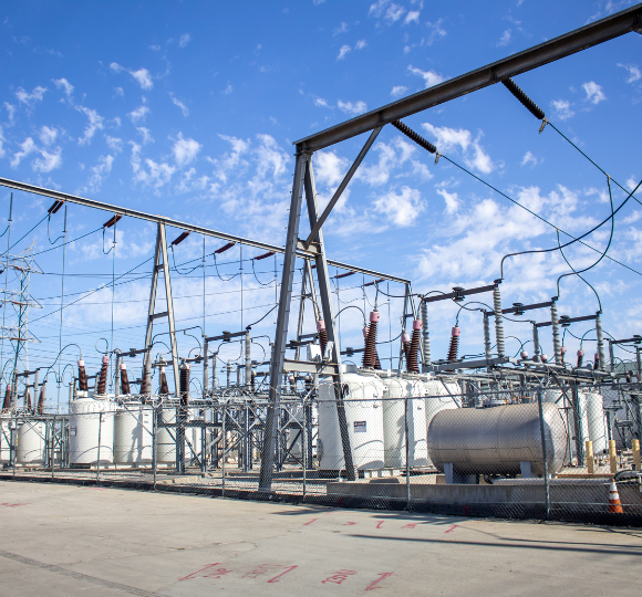 Electric power station with transformers and high-voltage lines under a blue sky